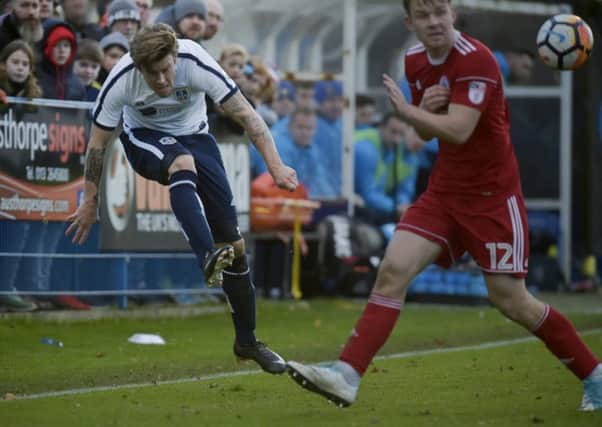 Kevan Hirst crosses the ball for Guiseley against Accrington Stanley.