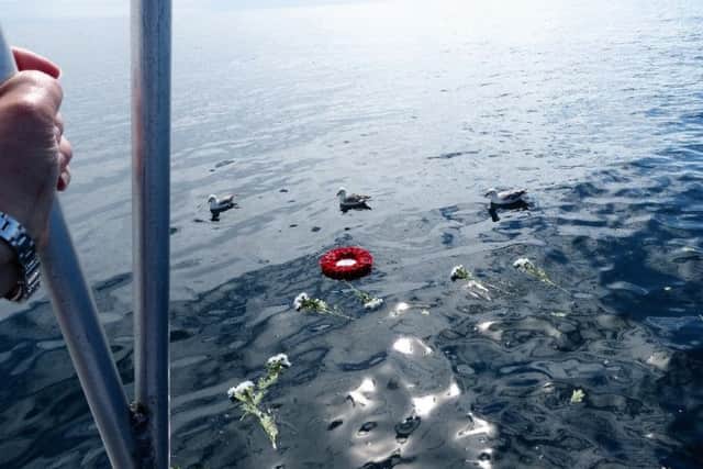A wreath and flowers were laid on water at the wreck site