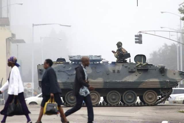 An armed soldier patrols a street in Harare, Zimbabwe. Zimbabwe's army said Wednesday it has President Robert Mugabe and his wife in custody and is securing government offices and patrolling the capital's streets following a night of unrest that included a military takeover of the state broadcaster.