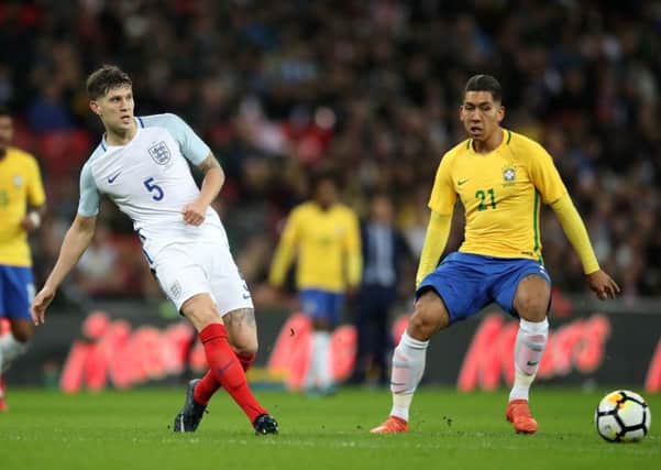 England's John Stones (left) in action with Brazil's Roberto Firmino.