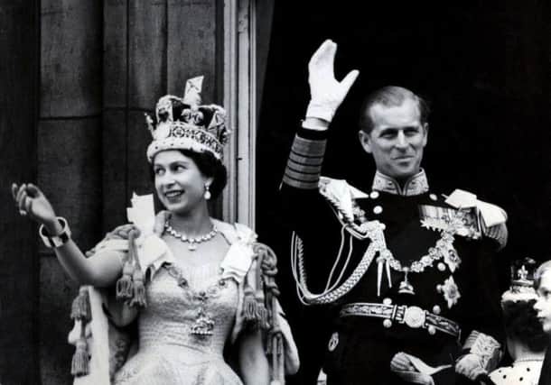 Queen Elizabeth II wearing the Imperial State Crown, and the Duke of Edinburgh, in the uniform of Admiral of the Fleet, waving from the balcony of Buckingham Palace after the Queen's Coronation. The Royal couple celebrate their platinum wedding anniversary on November 20. PA Wire