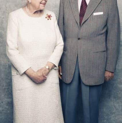 Photo issued by Camera Press of Queen Elizabeth II and the Duke of Edinburgh by British photographer Matt Holyoak, taken in the White Drawing Room at Windsor Castle in early November, pictured against a platinum-textured backdrop, in celebration of their platinum wedding anniversary on November 20. The Queen is wearing a cream day dress by Angela Kelly and a 'Scarab' brooch in yellow gold, carved ruby and diamond, designed by Andrew Grima,  and given as a personal gift from the Duke to The Queen in 1966. Matt Holyoak/CameraPress/PA Wire