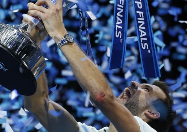 Grigor Dimitrov celebrates and holds up the ATP World Finals trophy (Picture: Alastair Grant/AP).