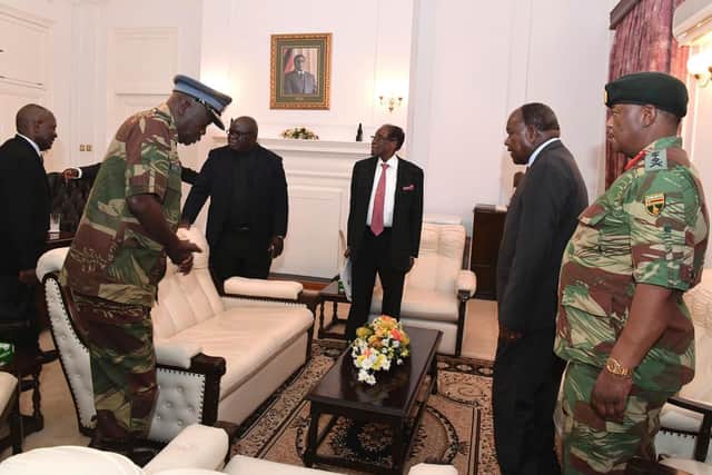 Zimbabwean President Robert Mugabe, centre rear, meets with Defence Forces Generals at State House, in Harare, Sunday, Nov, 19, 2017. Members of the ZANU PF Central committee have fired Mugabe as their chief and replaced him with former vice president Emmerson Mnangagwa. (Zimbabwe Herald via AP)