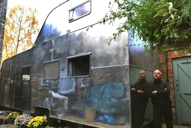 Tim Mitchinson reflected in the stainless steel of  his  Berkely double decker caravan in York.