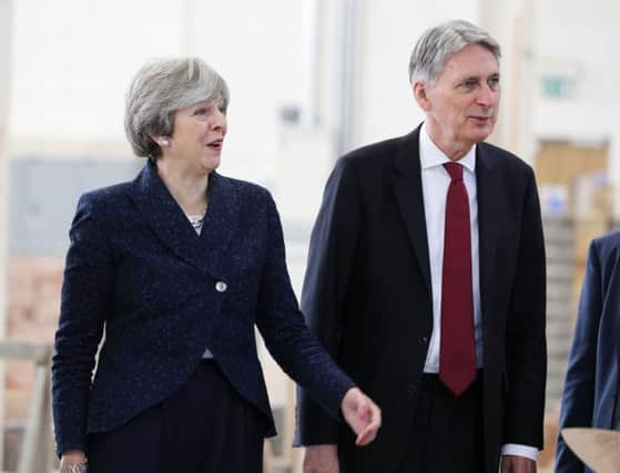 Theresa May and Chancellor of the Exchequer Philip Hammond during a visit to Leeds College of Building, the day after his Budget speech