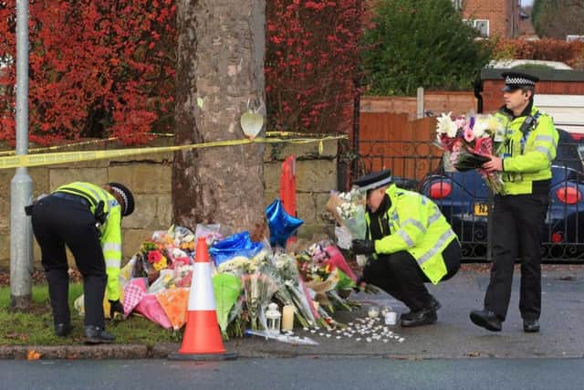 Police leaving flowers in tribute at the scene in Stonegate Road