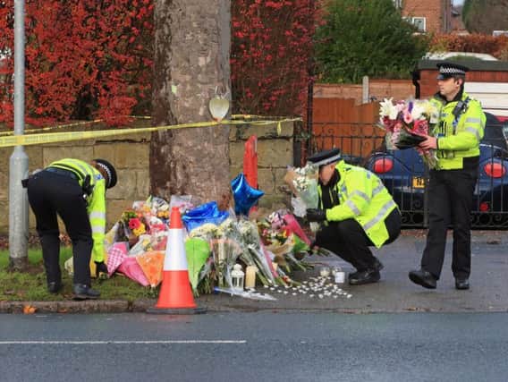 Police leaving flowers in tribute at the scene in Stonegate Road