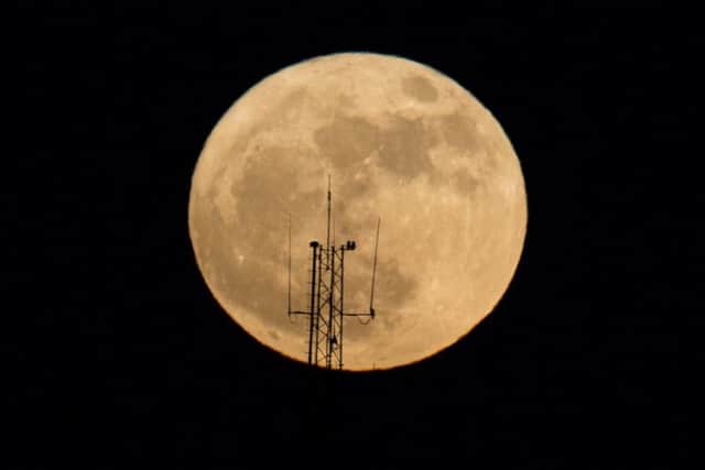 The moon rises over a building in Netanya, Israel. PIC: AP