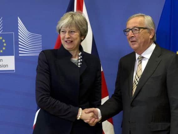 Theresa May shaking hands with Claude Juncker