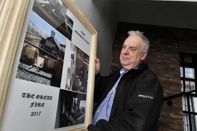 Ian Robson with a picture illustrating the 2017 fire. Picture by Richard Ponter 175412c