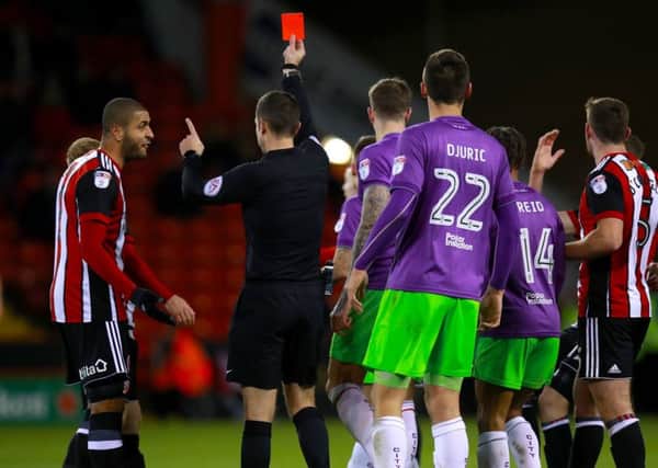 Referee David Coote shows the red card to Sheffield United's John Fleck (obscured)