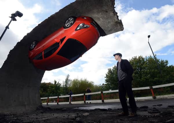 Artist Alex Chinneck with his temporary sculpture installation which popped up earlier this year beside the M1 Tinsley viaduct in Sheffield. PIC: Scott Merrylees