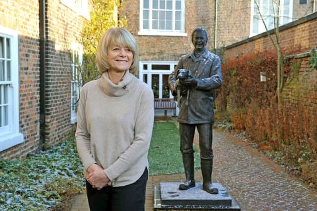 Dr Rosie Page, daughter of vet Alf Wight, alongside the life-size bronze statue of her father in the rear garden of his former home and practice at 23 Kirkgate - now The World of James Herriot museum. Picture by Tony Johnson.