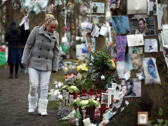 A woman looks at tributes to George Michael left in The Grove, Highgate. Picture: Jonathan Brady/PA Wire