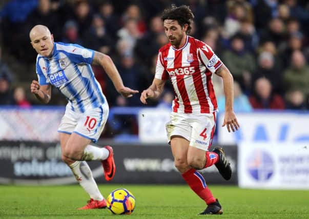 Stoke City's Joe Allen (right) and Huddersfield Town's Aaron Mooy battle for the ball. Picture: Richard Sellers/PA