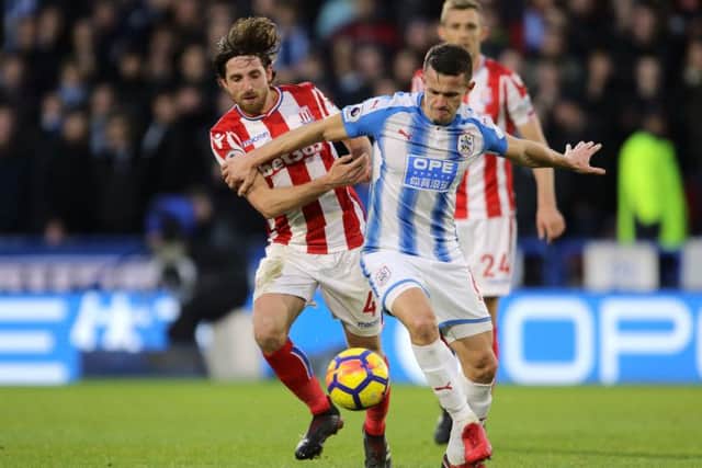 Huddersfield Town's Jonathan Hogg (right) and Stoke City's Joe Allen battle for the ball. Picture: Richard Sellers/PA