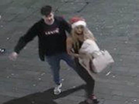 Handout CCTV still dated 23/12/2017 issued by Lincolnshire Police of a man and a woman they would like to speak to in connection with theft of a police officer's helmet on Lincoln High Street.