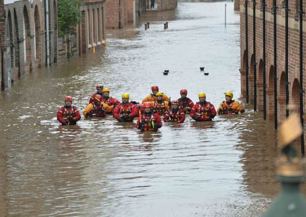 CITY SUBMERGED: Mountain rescue team members wade through floodwater in Skeldergate, in York city centre, on Boxing Day, 2015.