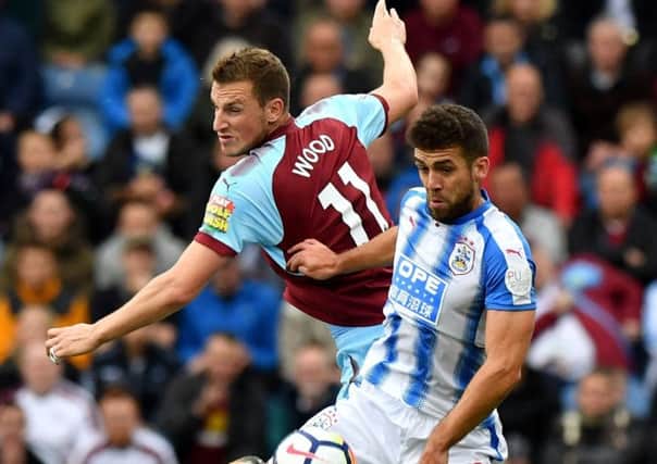 Burnley's Chris Wood (back) and Huddersfield Town's Tommy Smith battle for the ball during the Premier League match at Turf Moor.