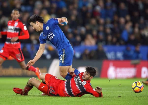 Leicester City's Shinji Okazaki and Huddersfield Town's Christopher Schindler (floor) battle for the ball Picture: Nigel French/PA