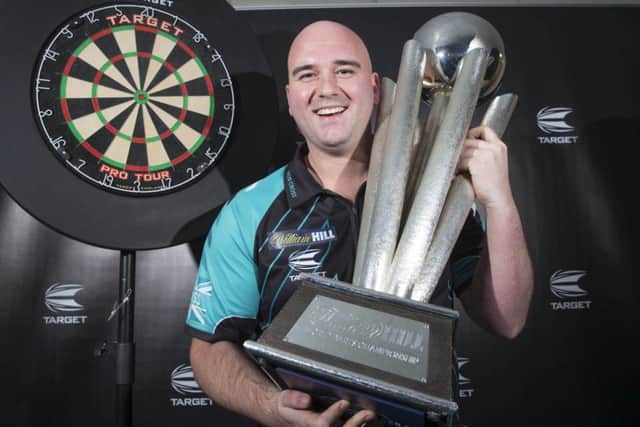 Rob Cross with the World Championship trophy at Target Darts HQ in Harlow (Picture: Steve Welsh/PA Wire).