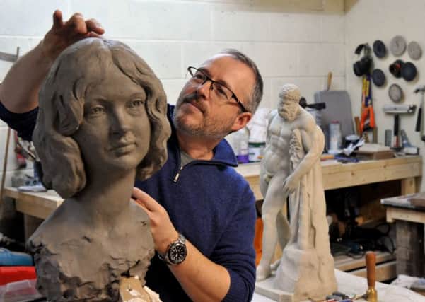 Sculptor Andrian Melka working on a bust of his partner Ruth in his studio