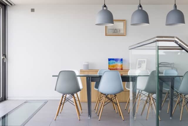 Jhe dining area with table by blacksmith James Godbold, Eames chairs and lights by Normann Copenhagen from John Lewis.