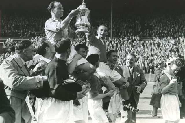On the shoulders of their triumphant team mates, Harry Johnston and Stanley Matthews hold the FA cup aloft in 1953.