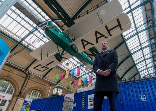 Artist Leonard Brown, in front of the lif- size replica of Amy Johnson's Gypsy Moth, which is hanging from the roof of Paragon Station, in Hull.
