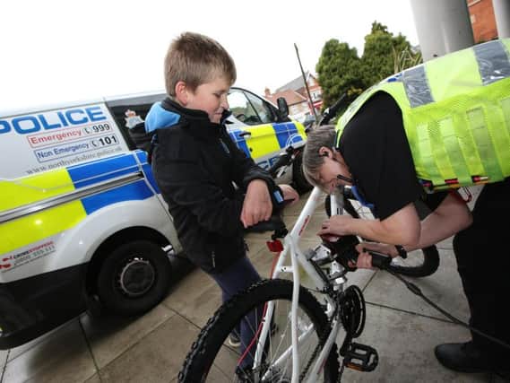 A police officer uses dot peen to mark a bike in York.