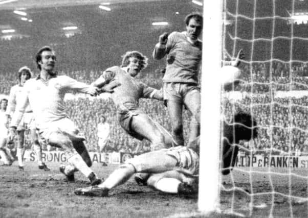 Peter Barnes forces his way past Paul Madeley and David Harvey to score the second Manchester goal