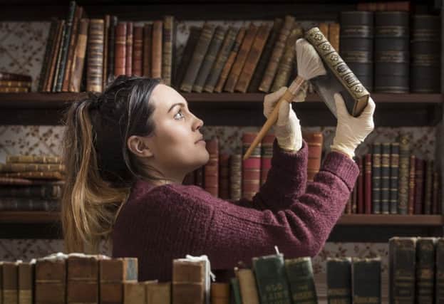 Museum manager Chloe Simm dusts an 1847 first addition of Wuthering Heights by Emily Bronte as the Bronte Parsonage Museum closes its doors to the public for annual conservation work and maintenance, in Haworth