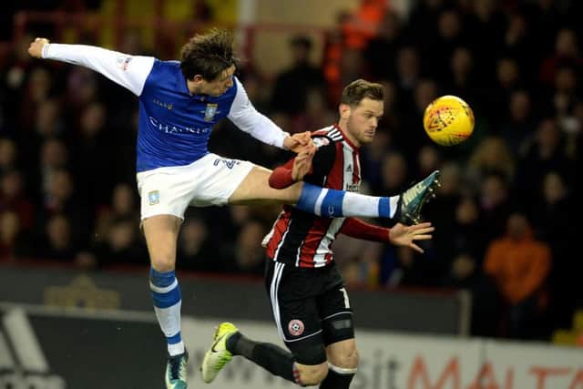 TIGHT TUSSLE: Adam Reach goes in high for the ball with Sheffield United's Richard Stearman at Bramall Lane on Friday night.  Picture: Bruce Rollinson