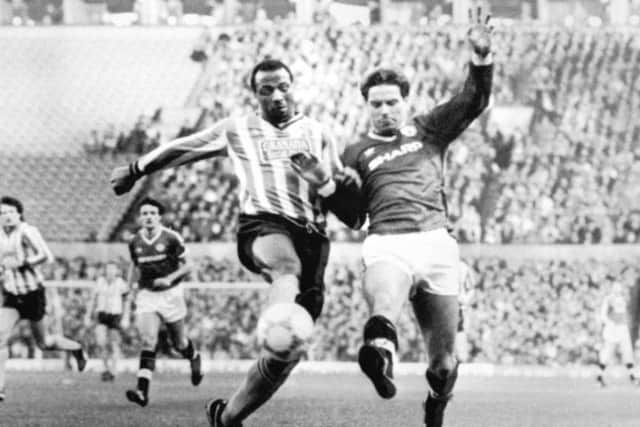 Coventry City's Cyrille Regis and Manchester United's John Sivebaek battle for the ball.