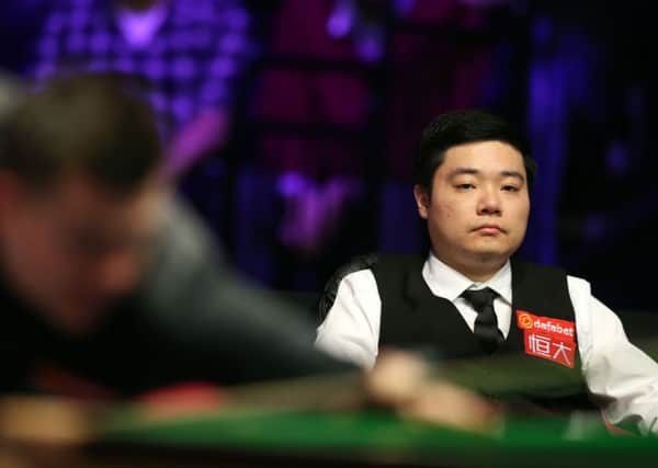Ding Junhui watches Ryan Day during day two of the 2018 Dafabet Masters at Alexandra Palace, London.