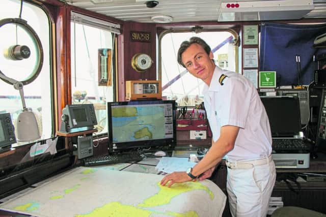 Second Navigational Officer Vadim Novikov explaining to a guest how to plot a route at sea using only the sun and the stars. PA Photo/Chris Wiltshire.