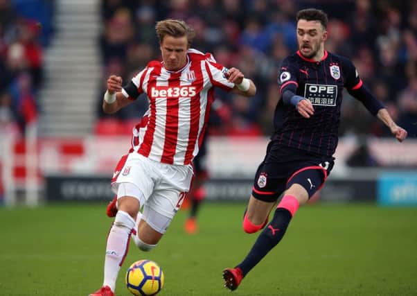 Stoke City's Moritz Bauer (left) and Huddersfield Town's Scott Malone battle for the ball. Picture: Nigel French/PA