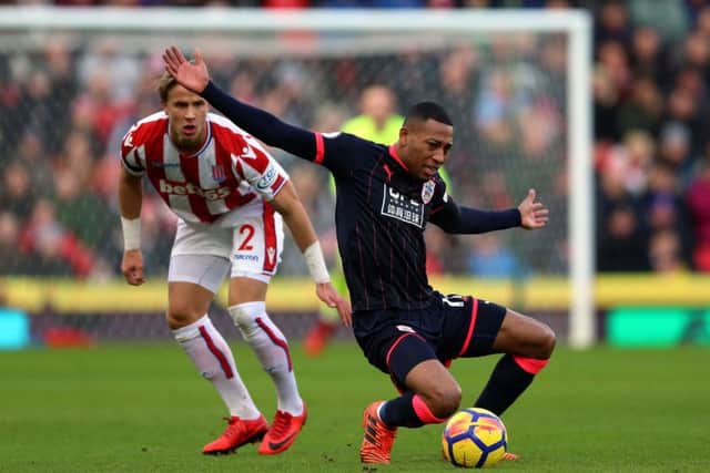 Stoke City's Moritz Bauer and Huddersfield Town's Rajiv van La Parra (right) battle for the ball. Picture: Nigel French/PA