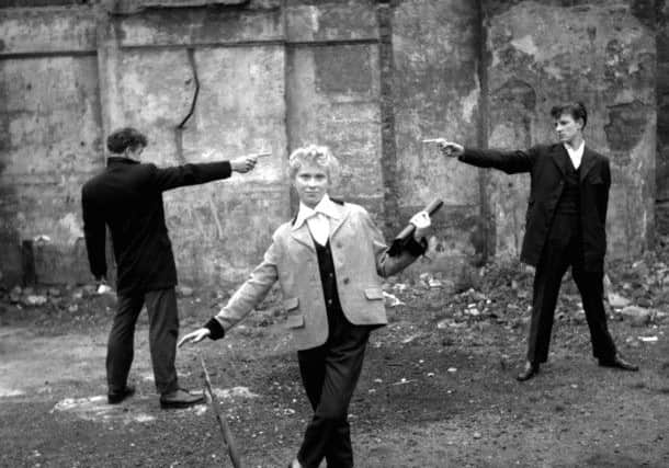 A Question of Honour, taken in January 1955 by Ken Russell for TopFoto, with 16 year old Eileen from Bethnal Green, with two teddy boys "duelling" over her on an East End bombsite.