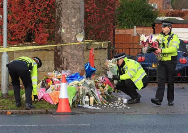 Police leaving flowers in tribute at the scene in Stonegate Road. PIC: PA