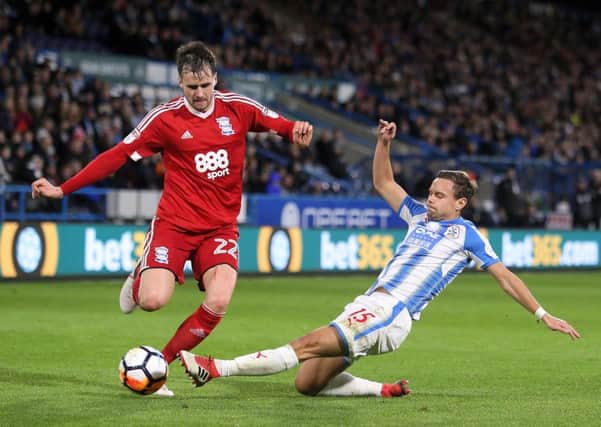 Birmingham City's Carl Jenkinson (left) and Huddersfield Town's Chris Lowe battle for the ball during the Emirates FA Cup, fourth round match at the John Smith's Stadium.