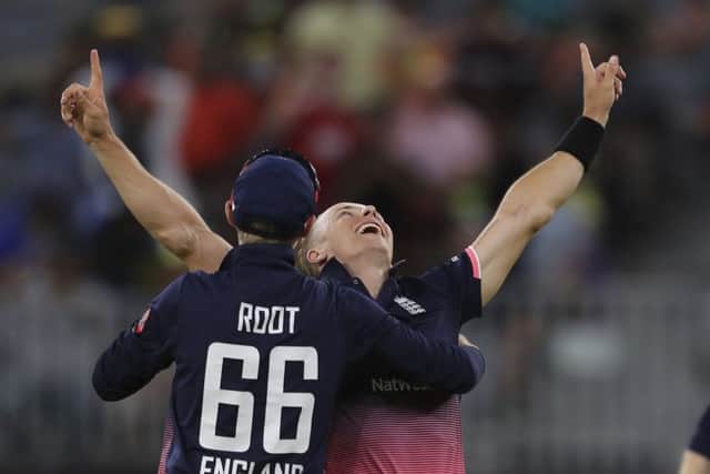 England's Tom Curran, right, celebrates with Joe Root after taking Australia's final wicket. Picture: AP/Trevor Collens