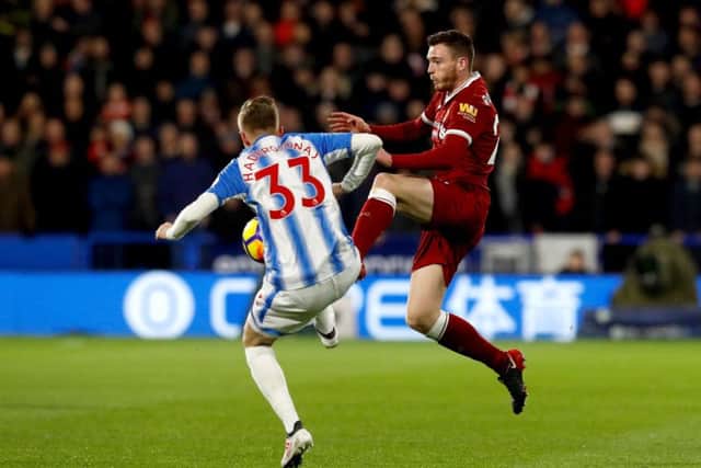 Liverpool's Andrew Robertson (right) and Huddersfield Town's Florent Hadergjonaj (left) battle for the ball. Picture: Martin Rickett/PA