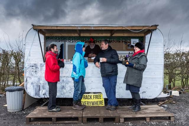 Anti-fracking campaigners enjoying a warm drink and a chat in front of the new refreshment caravan near the entrance of the Third Energy fracking site on the edge of the village.