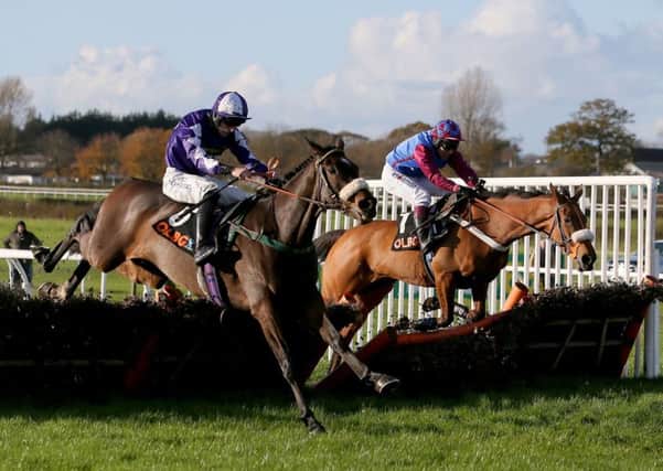 Lady Buttons and Adam Nicol nearside join battle with La Bague Au Roi on Charlie Hall Chase day at Wetherby.