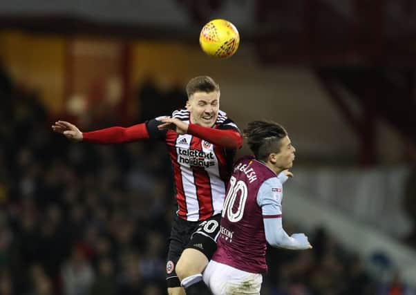 Ready for return: Lee Evans in aerial combat withVilla's Jack Grealish ahead of facing Wolves.