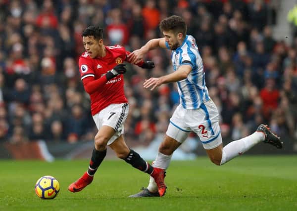 Manchester United's Alexis Sanchez (left) and Huddersfield Town's Tommy Smith battle for the ball.