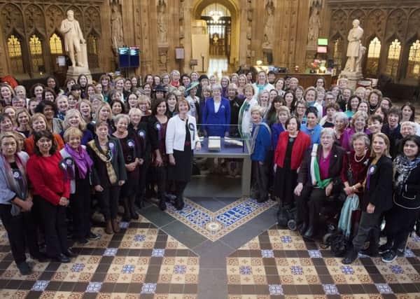Theresa May is pictured with female MPs and peers to mark the centenary of the Representation of People Act.