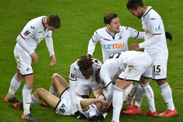 Swansea City's Daniel James (on ground) is mobbed by his team-mates after scoring his side's eighth goal against Notts County. Picture: Simon Galloway/PA